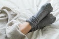 Feet crossed with gray socks on bed under blanket Royalty Free Stock Photo