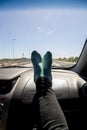 Feet on the dashboard of the car while traveling on route.