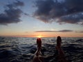 Feet enjoy the view of a Waikiki Sunset from above the water Royalty Free Stock Photo