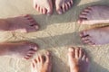 Feet of a family in the fine sand