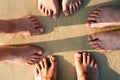 Feet of a family in the fine sand of the beach