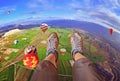 Feet of girl in sports shoes over the edge in the blue sky