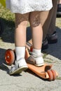 Feet girls close-up on a scooter. Child riding scooter. Safety ride on a children`s scooter. Vertical photo Royalty Free Stock Photo