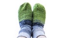 Feet In Green And Gray Handmade Knitted Woollen Socks on White Background. Keeping Yourself Warm Concept