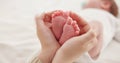 Feet, hands and mother with baby, love and support for care, health and wellness in bedroom. Closeup, family or mama Royalty Free Stock Photo