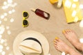 Feet, hat, shades, sunscreen and book on beach Royalty Free Stock Photo