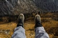 feet with high top shoes with a valley in the background