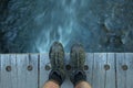 Feet on a wood bridge with flowing water down below Royalty Free Stock Photo