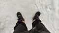 Feet of Hunter or fisherman in big warm boots on a cold winter day on snow. Top view