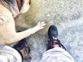 Feet of Hunter or fisherman in big warm boots And paws of dog on snow. Top view. Fisherman on ice of river, lake