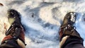 Feet of Hunter or fisherman in big warm boots on a winter day on snow. Top view. A fisherman on the ice of a river, lake