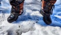 Feet of Hunter or fisherman in big warm boots on a winter day on snow. Top view. A fisherman on the ice of a river, lake