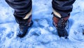 Feet of Hunter or fisherman in big warm boots on a winter day on snow. Top view. A fisherman on the ice of a river, lake