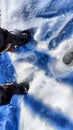 Feet of Hunter or fisherman in big warm boots on a winter day on snow. Top view. A fisherman on the ice of a river, lake, Royalty Free Stock Photo