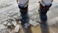 Feet of Hunter or fisherman in big warm boots on a winter day on snow. Top view. Fisherman on the ice of a river, lake