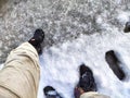 Feet of Hunter or fisherman in big warm boots on a winter day on snow. Top view. Fisherman on the ice of a river, lake