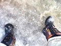 Feet of Hunter or fisherman in big warm boots on a winter day on snow. Top view. Fisherman on the ice of a river, lake