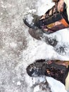 Feet of Hunter or fisherman in big warm boots on a winter day on snow. Top view. Fisherman on the ice of a river, lake