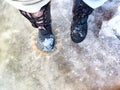 Feet of Hunter or fisherman in big warm boots on a winter day on snow. Top view. Fisherman on the ice of a river, lake