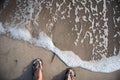 Feet in jandals on the beach next to water Royalty Free Stock Photo