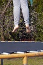 Feet jumping over a black trampoline Royalty Free Stock Photo