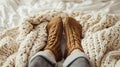 feet in knitted woollen socks peeking out from under a knitted warm blanket in winter. warm and cosy