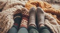 feet in knitted woollen socks peeking out from under a knitted warm blanket in winter. warm and cosy