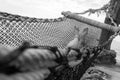 Feet and legs of a girl lying on net hammock bed Royalty Free Stock Photo