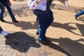 Feet and legs and shadows of protestors on sidewalk