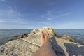 Feet and legs of a young man sunbathing on the rocks surrounded by the sea Royalty Free Stock Photo