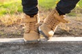 Feet of a little boy in brown nubuck shoes in autumn in a city park. Comfortable waterproof demi-season shoes