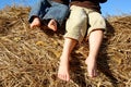 Feet of Little Boys Sitting on Top of Hay Bale Royalty Free Stock Photo