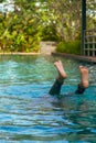 Feet looking out upside down from swimming pool. Summe fun vacation Royalty Free Stock Photo