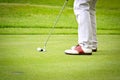 Feet of male golf player putting at green Royalty Free Stock Photo