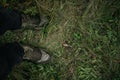 Feet of a man in hiking boots standing on the grass Royalty Free Stock Photo