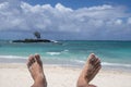 feet of a man lying on the sand of a beach paradise symbol of happiness Royalty Free Stock Photo