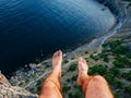 Feet of man sitting freely on high mountain nature over sea during summer vacation