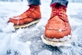 Feet of a man on a snowy sidewalk in brown boots