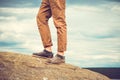 Feet man standing on rocky mountain outdoor