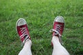 feet of man wearing red sneakers lying in the grass Royalty Free Stock Photo