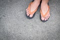 Feet of a man wearing sandals on concrete floor. Royalty Free Stock Photo