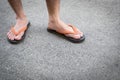 Feet of a man wearing sandals on concrete floor. Royalty Free Stock Photo