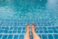 Feet of man who is sitting on the tile stairs