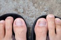 Feet of men wearing black sandals