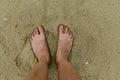 Feet naked barefoot without shoes burrow in the sand on a sandy beach, white skin Royalty Free Stock Photo