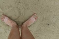 Feet naked barefoot without shoes burrow in the sand on a sandy beach, white skin Royalty Free Stock Photo