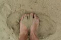 Feet naked barefoot without shoes burrow in the sand on a sandy beach, white skin Royalty Free Stock Photo