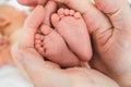 Feet of a newborn baby boy wrapped in the arms of his father Royalty Free Stock Photo