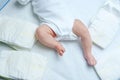 Feet of newborn baby on changing table with diapers. Cute little girl or boy two weeks old. Dry and healthy body and Royalty Free Stock Photo