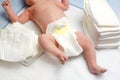 Feet of newborn baby on changing table with diapers. Cute little girl or boy two weeks old. Dry and healthy body and Royalty Free Stock Photo